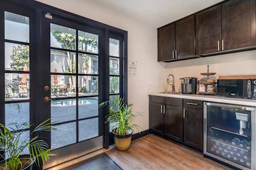 A modern kitchen with dark wood cabinets and a black door leading to a balcony.