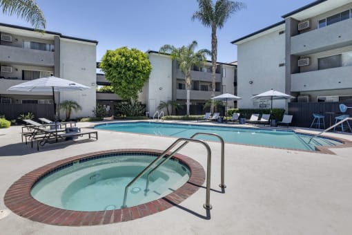 a swimming pool with a hot tub in front of a building