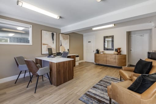 a living room with a desk and chairs