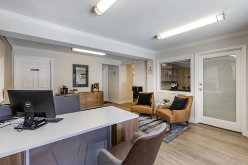 a living room with a desk and chairs