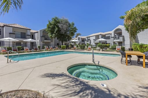 Dive into relaxation in our pool oasis with a hot tub and shaded lounging area at Boulders at Lookout Mountain Apartment Homes, Phoenix, AZ