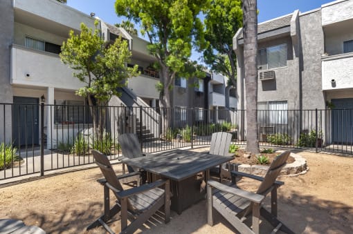 a patio with a table and chairs in front of an apartment building at Scripps Poway Villas, Poway California