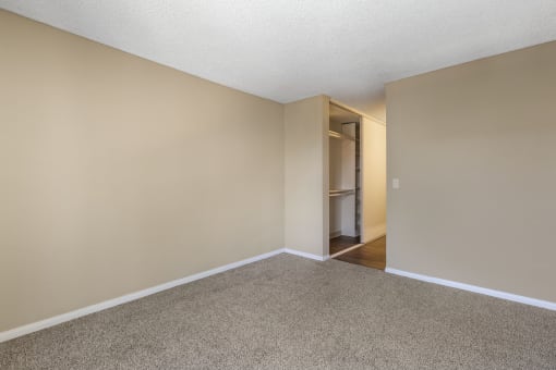 a bedroom with beige walls and a carpeted floor