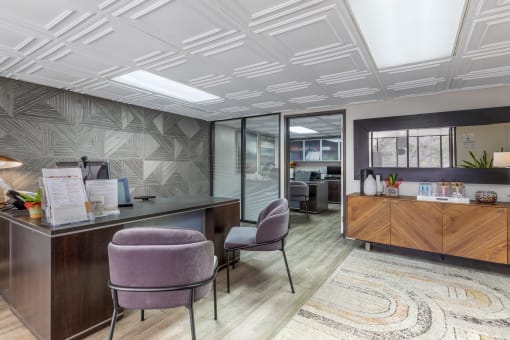 Step into Independence Plaza's chic lobby, featuring plush purple chairs and a welcoming leasing office—where luxury meets convenience.