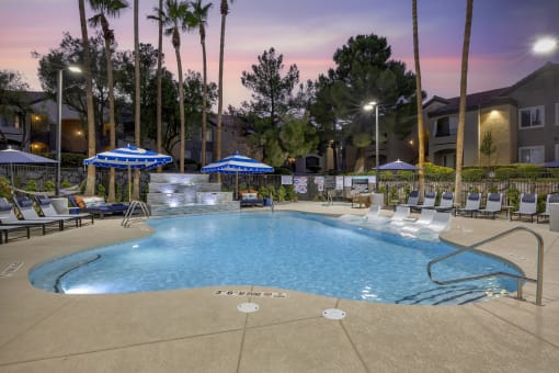 The shimmering water reflects the colors of the sunset, creating a serene atmosphere perfect for unwinding after a long day at our updated pool.