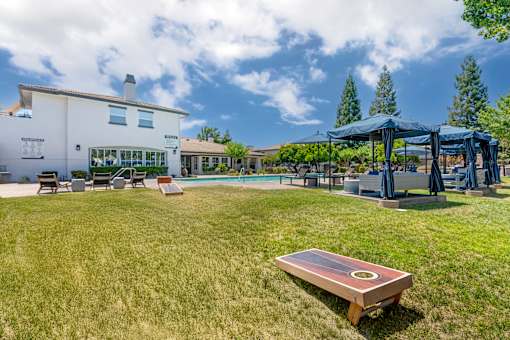 Next to our pool deck, a grassy area with cornhole boards invites friendly outdoor fun with neighbors.