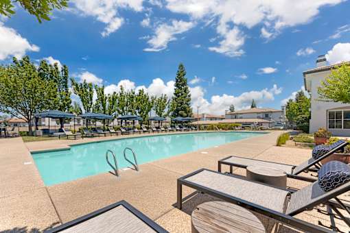 Dive into pure relaxation at Ascent at the Galleria’s pool deck in Rosevilla, CA—adorable cabanas and plush lounge chairs surround a sparkling pool, offering serene and stylish outdoor lounging vibes.