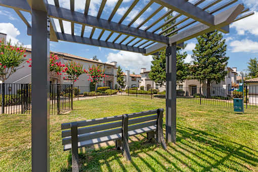 Our gated dog park features a semi-shaded gazebo and comfortable seating, creating a relaxing space for pet owners while their dogs play and socialize at Ascent at the Galleria.
