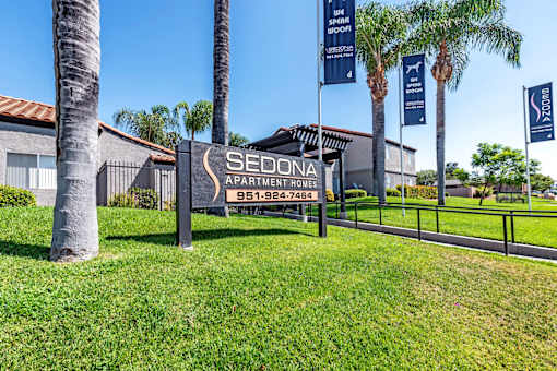 Sedona Apartments in Moreno Valley welcomes you with a modern, inviting entrance framed by lush landscaping and stylish, well-lit pathways.