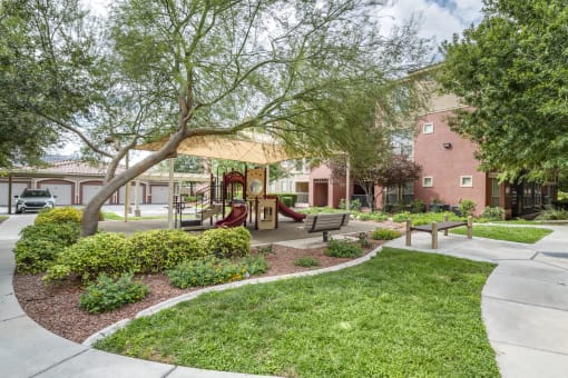 Apartments Near Downtown Las Vegas, NV - Sonata Apartments - Tot Lot With Beautiful Landscaping, Bench, and Made In The Shade Play Equipment System. at Sonata Apartment Homes, Las Vegas, Nevada