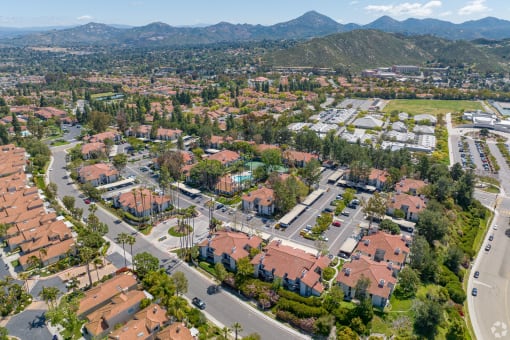 an aerial view of a neighborhood with houses and trees and mountains in the background at La Serena, San Diego, California