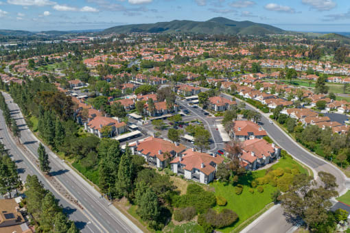 an aerial view of a neighborhood with red roofs and green grass at La Serena, San Diego, CA