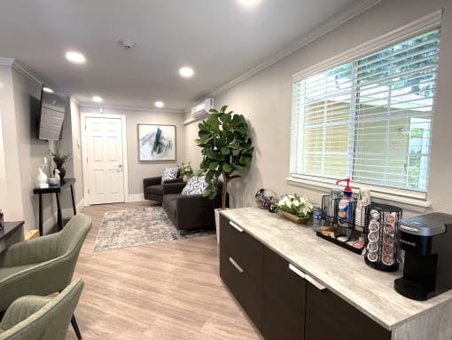 a living room with a couch and a counter with a coffee machine