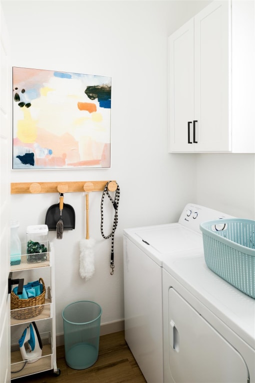 a small laundry room with a washing machine and a painting on the wall at Villas on Ash, Arizona, 85234