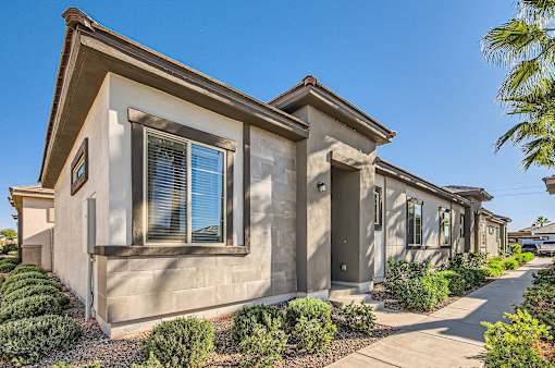 Building with bushes and a sidewalk at Hampton Meridian, Apache Junction, AZ