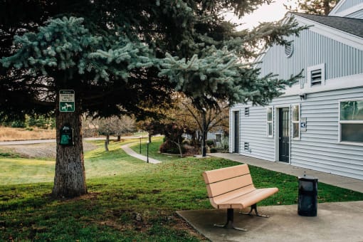 a bench sitting next to a tree in front of a house