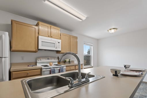 a kitchen with wooden cabinets and a stainless steel sink