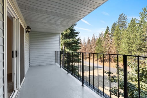 a large balcony with a view of the forest