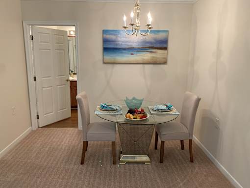 A dining room with a glass table and chairs.