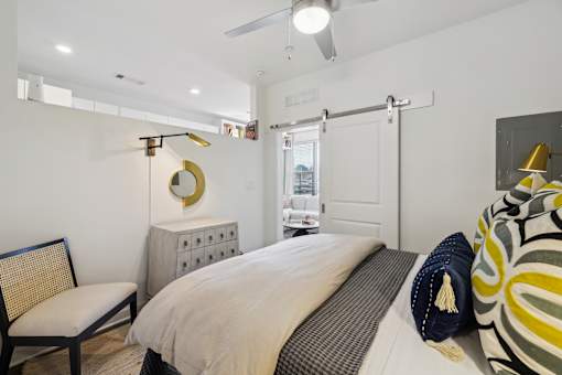 a bedroom with a bed and a dresser and a door to a bathroom at Link Apartments® Broad Ave, Memphis