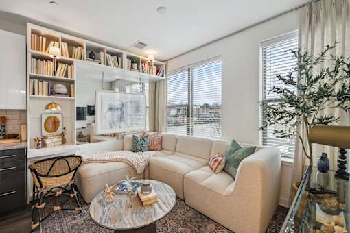 a living room with a couch and a table     and a window at Link Apartments® Broad Ave, Memphis