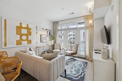 a living room with a white couch and a large window at Link Apartments® Broad Ave, Memphis