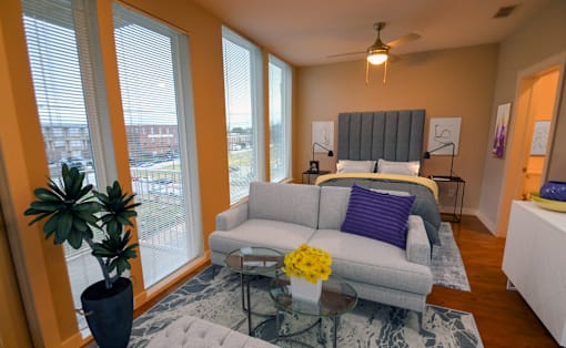 a living room with a couch and a bed in a room with large windows at Link Apartments® Canvas, Atlanta, GA, 30312