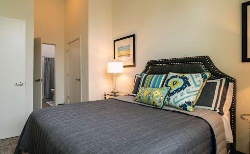 a bedroom with a bed and a door to a bathroom at Link Apartments® Canvas, Atlanta, GA, 30312