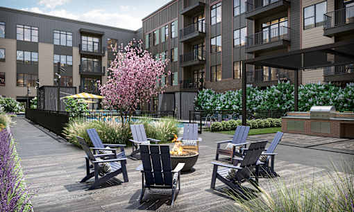 a patio with chairs and a fire pit in front of an apartment building at Link Apartments® Broad Ave, Memphis, Tennessee