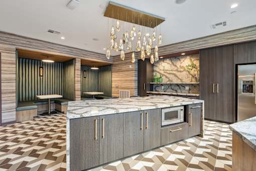 a large kitchen with marble countertops and a chandelier at Link Apartments® Broad Ave, Memphis, TN