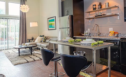 a kitchen with an island and two chairs in front of it at Link Apartments® Canvas, Georgia, 30312