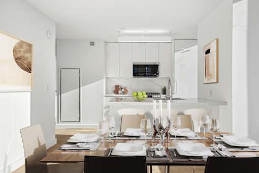 A modern dining room with a wooden table set for a meal.