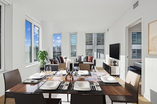 A dining room with a long table set for a meal.