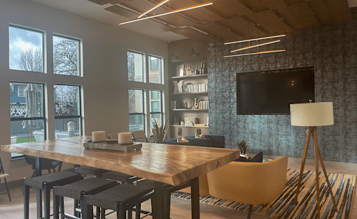 a room with a table and chairs and a flat screen tv on the wall at Link Apartments® Canvas, Atlanta, GA
