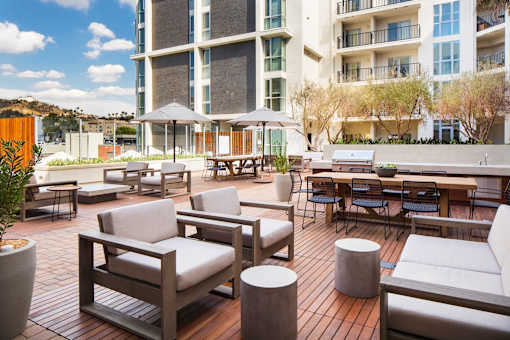 A patio with a table and chairs and a building in the background.