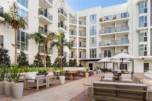 A white apartment building with a patio area in front.