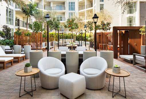 A patio with white chairs and tables.