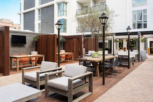 A patio with a table and chairs is surrounded by buildings.