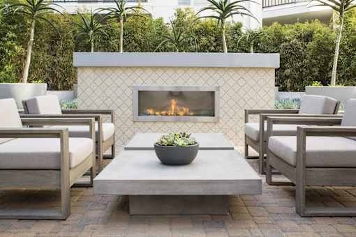 A fireplace with a bowl of flowers in front of it.