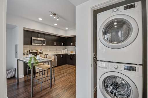 A modern kitchen with a washer and dryer built into the cabinetry.