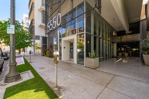 A building with the number 550 on it has a parking sign in front of it.