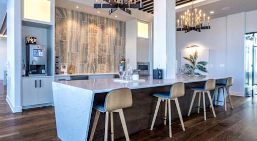 A modern kitchen with a bar area and a dining table.