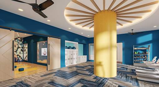 A room with a yellow column and a ceiling fan.