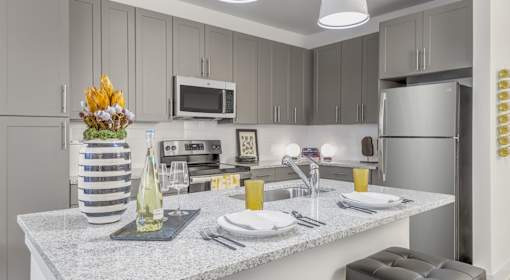 A kitchen with a countertop and a microwave above it.