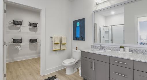 A bathroom with a toilet, sink, and a mirror.