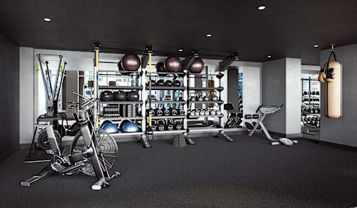 A gym with a variety of equipment including weights and a punching bag.