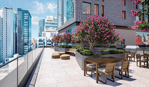 A patio with a table and chairs overlooks a city skyline.