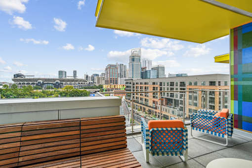 a rooftop terrace with chairs and a view of the city at Link Apartments® Mint Street, Charlotte, NC