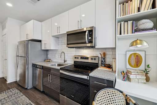 a kitchen with stainless steel appliances and white cabinets at Link Apartments® Broad Ave, Memphis, Tennessee