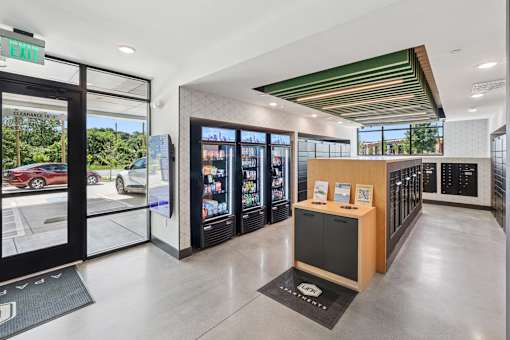 A modern office lobby with a reception desk and a view of the parking lot outside at Link Apartments® CYKEL Apartments, Charlotte, NC, 28208